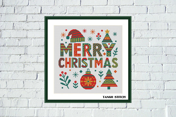 Framed Christmas-themed artwork with 'Merry Christmas' text on a white brick wall background. Merry Christmas holiday festive cross stitch pattern - Tango Stitch