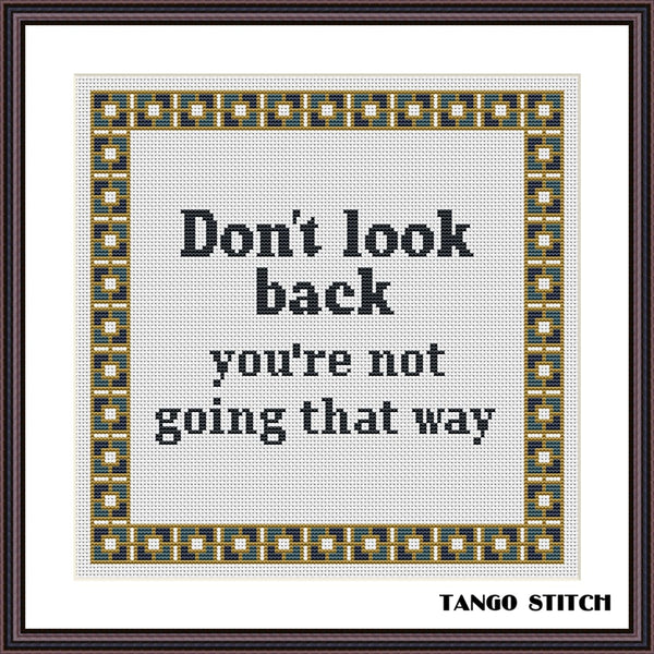 Cross-stitched text 'Don't look back you're not going that way' with decorative border, brand 'Tango Stitch' at the bottom. Don't look back motivational cross stitch pattern - Tango Stitch