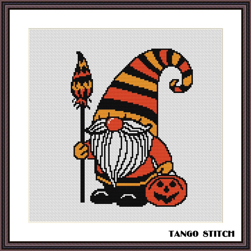 Halloween-themed gnome with striped hat and pumpkin, cross-stitch pattern on a white background. Halloween gnome festive spooky cross stitch pattern - Tango Stitch